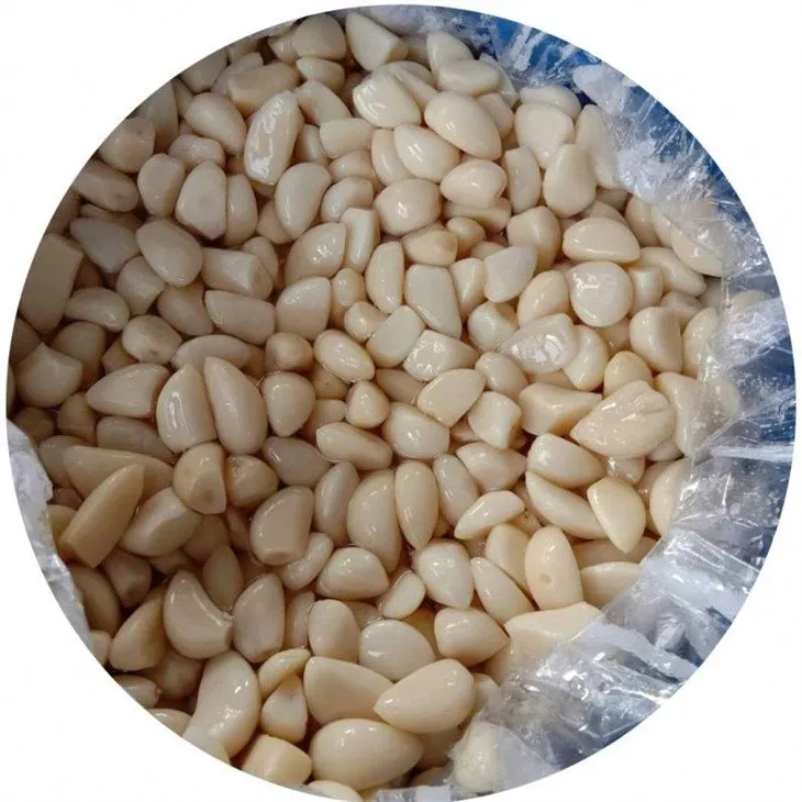 Salty peeled white garlic in drums